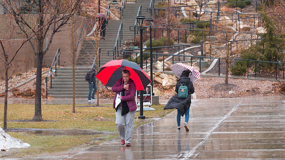 Students walking across campus in the rain