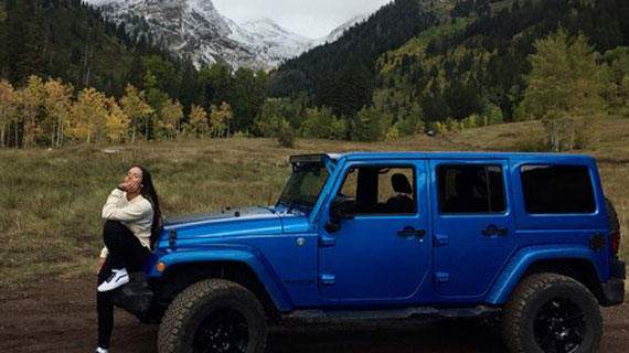 Student posing in front of their Jeep