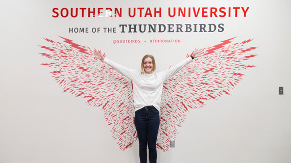 student standing in front of t-bird wings