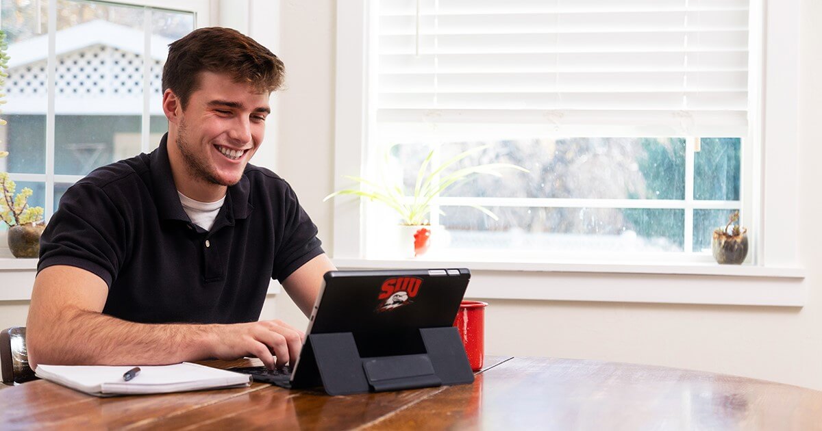 Smiling student looking at laptop