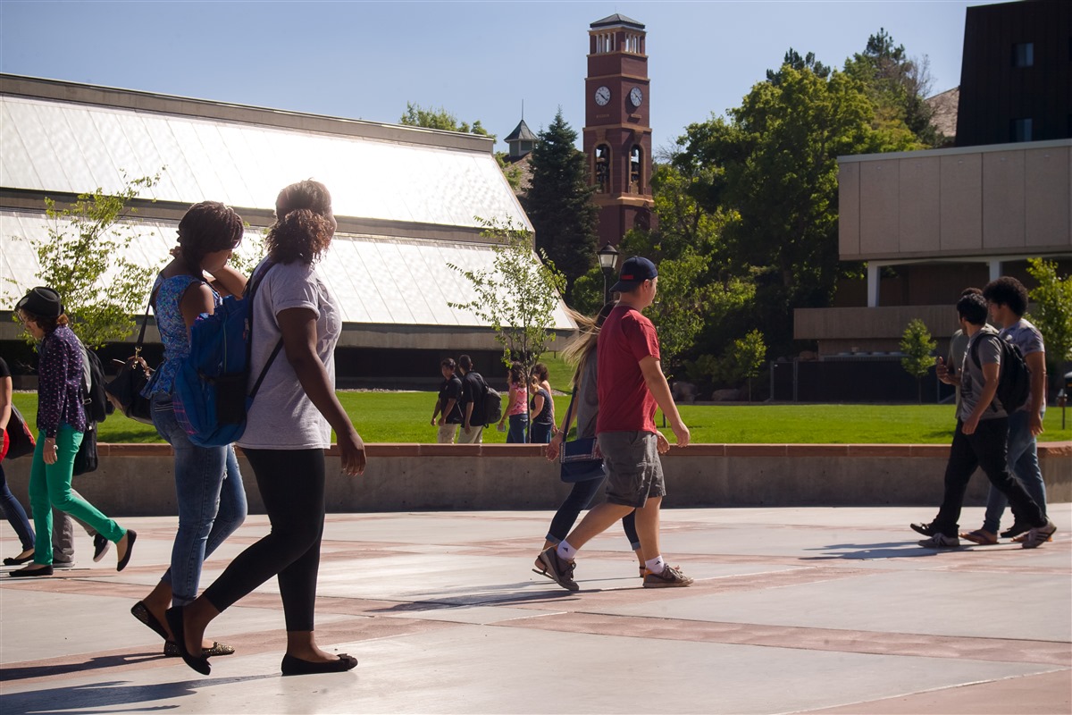 Students walking on campus with the clock tower in the background 7