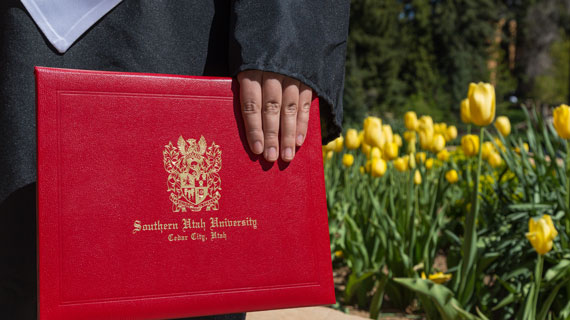 SUU graduate holding a diploma