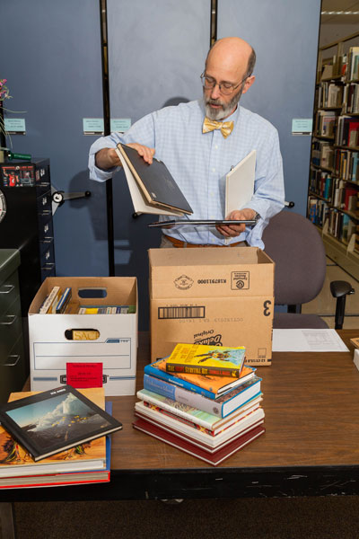 Richard Saunders behind pile of books